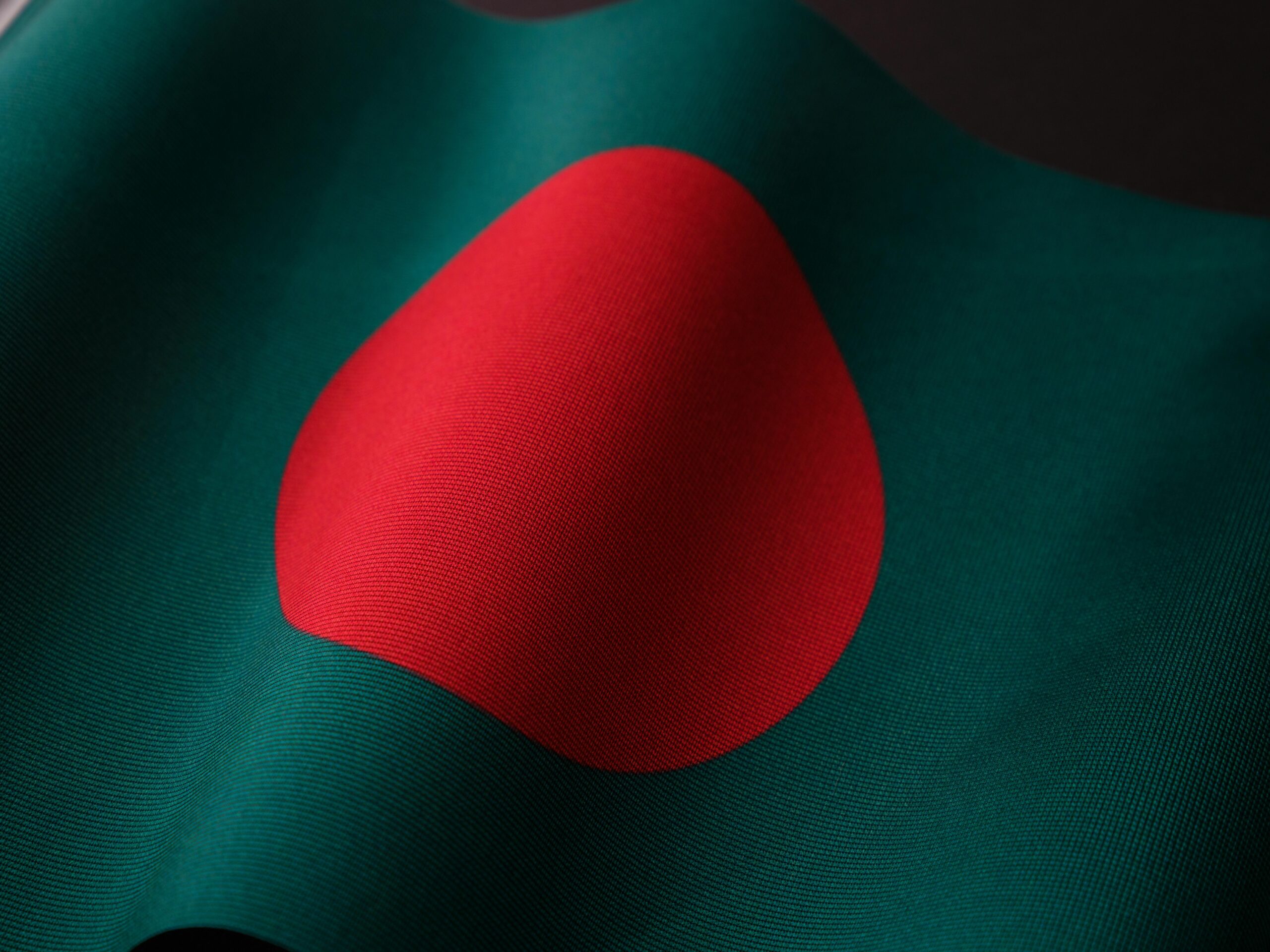 Close-up of the vibrant Bangladesh flag with rich colors and fabric texture.